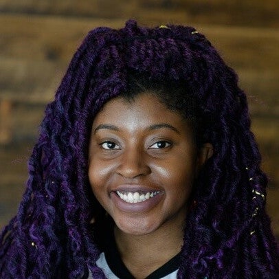 headshot of Rizel Scarlett smiling with purple faux locs