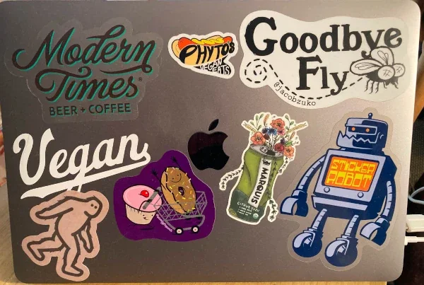 DJ Billings' laptop with various decals including a muffin