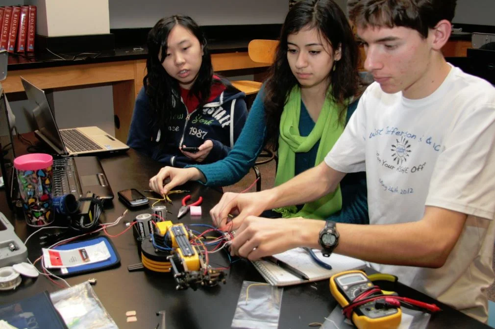 Three students working with Ardunio in science class