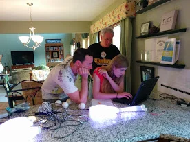 Lauren, Charles, and her dad around the laptop