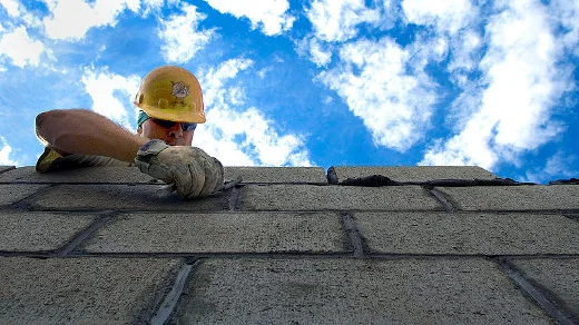 Construction worker building a cinderblock wall