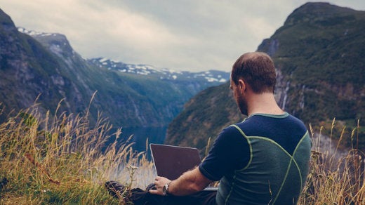 Man at laptop on a mountain