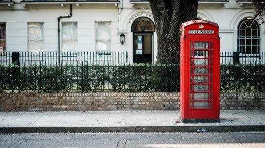 Red telephone booth on a street in England