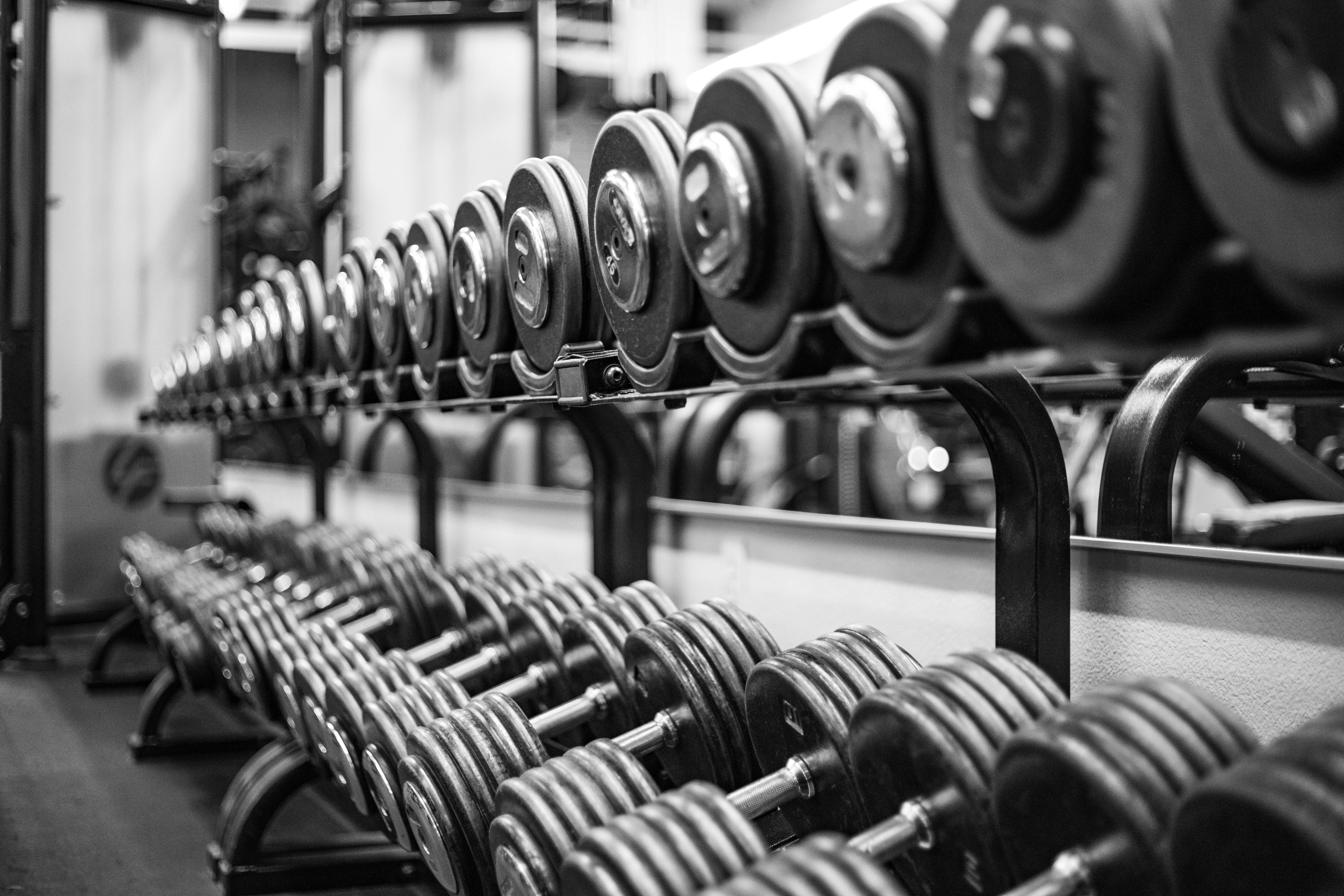 gray scale photo of dumbbell weights for strength training