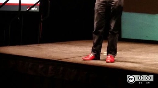 Jim Whitehurst wears his red shoes on stage at All Things Open 2015