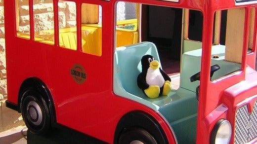 tux the penguin driving a toy bus