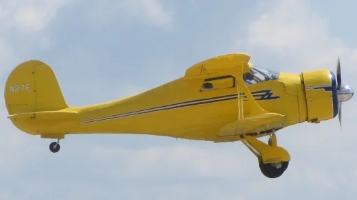 Yellow plane flying in the air, Beechcraft D17S