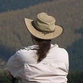 Rear view of a person with a ponytail wearing a wide-brim canvas hat