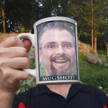 Crazy-looking guy drinking his own head from a coffee cup